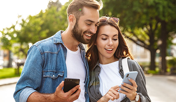 Happy couple looking at their cellphones